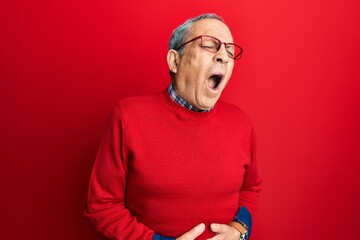 Handsome senior man with grey hair wearing casual clothes and glasses with hand on stomach because nausea, painful disease feeling unwell. ache concept.