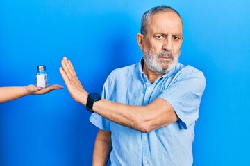 Handsome senior man with beard being offering salt with open hand doing stop sign with serious and...