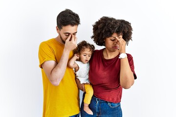 Interracial young family of black mother and hispanic father with daughter tired rubbing nose and eyes feeling fatigue and headache. stress and frustration concept.