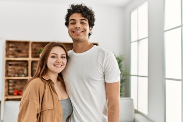 Obraz premium Young couple smiling happy and hugging standing at home.