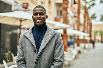 Obraz premium Young african american man smiling happy standing at the city