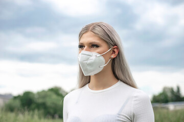 junge blonde Frau mit Maske