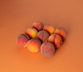 Fresh peaches on orange background, square setting