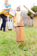 Familie spielt Wikingerschach (Kubb) im Garten. Familie plays viking chess in the garden. Wooden Kubb King.