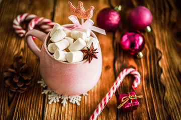 Christmas drink background, pink cup with hot chocolate and marshmallows on a wooden table near New Year's decor. Cocoa Christmas drink, copy space, bokeh effect, drink mug Christmas holiday 