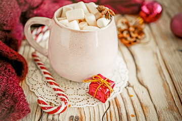 Fototapeta na wymiar Christmas drink background, pink cup with hot chocolate and marshmallows on a wooden table near New Year's decor. Cocoa Christmas drink, copy space, bokeh effect, drink mug Christmas holiday 