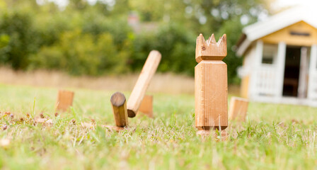 Wikingerschach (Kubb) aus Holz in Garten aufgestellt. Wooden Kubb sticks in garden.