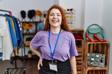 Young redhead woman working as manager at retail boutique with a happy and cool smile on face. lucky person.