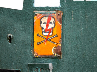 Electricity, high voltage warning sign, old fashioned worn out retro metal plate with skull and bones, lightning symbol, grunge. Danger concept, electric power life threat, object detial, nobody