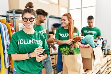 Group of young volunteers smiing happy working at charity center.