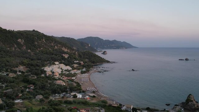 Aerial drone view over western coast and Pelekas beach at sunset. Island of Corfu, Greece.