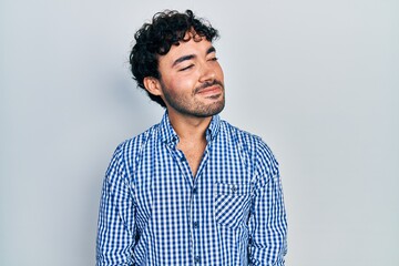 Obraz premium Young hispanic man wearing casual clothes looking away to side with smile on face, natural expression. laughing confident.
