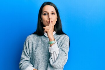 Young hispanic woman wearing casual clothes asking to be quiet with finger on lips. silence and secret concept.