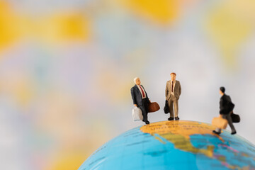 Miniature people Group Business man mini figures standing thinking on Global ball map background with copy space using as thinking business plan and how to solve problem Strategy Planning concepts