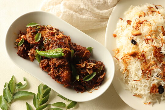 Kerala style spicy chiken roast Served with ghee rice made of basmati rice garnished with fried onions and cashews
