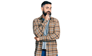 Hispanic man with beard wearing casual shirt looking confident at the camera with smile with crossed arms and hand raised on chin. thinking positive.