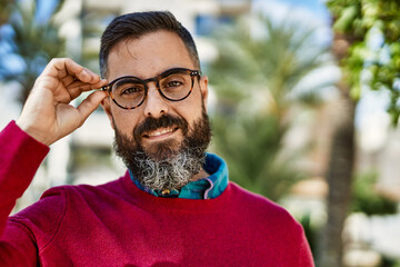 Young hispanic executive man smiling happy standing at the city.