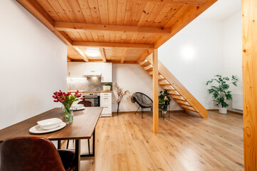 Loft apartment with kitchen, which is under wooden construction forming second floor with...