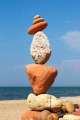 Rock zen pyramid of colorful pebbles on a background of blue sky