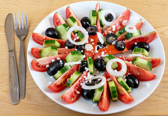 Vegetable slices of cucumbers, tomatoes and olives, with feta cheese and olive oil