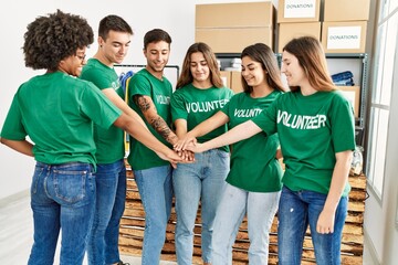 Fototapeta premium Group of young volunteers smiing happy with hands together at charity center.