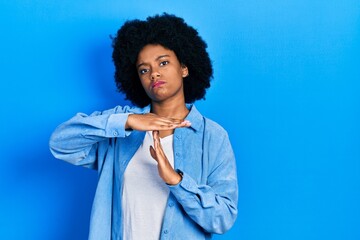 Fototapeta na wymiar Young african american woman wearing casual clothes doing time out gesture with hands, frustrated and serious face