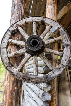 An old wooden cart wheel hangs at the entrance to the village blacksmith shop. A vintage piece of an old rural lifestyle.
