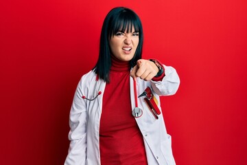 Young hispanic woman wearing doctor uniform and stethoscope pointing displeased and frustrated to the camera, angry and furious with you