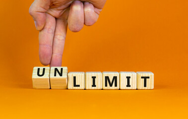 Limit or unlimit symbol. Businessman turns cubes, changes words 'limit' to 'unlimit'. Beautiful orange table, orange background, copy space. Business, limit or unlimit concept.