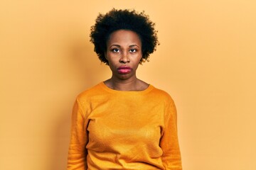 Obraz na płótnie Canvas Young african american woman wearing casual clothes relaxed with serious expression on face. simple and natural looking at the camera.