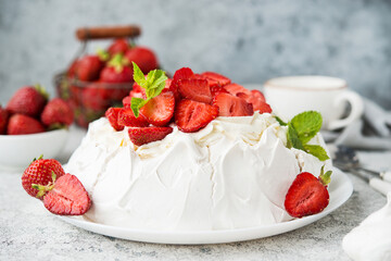 Pavlova cake with meringue and fresh strawberries on a light background, selective