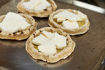 Sopes with cheese cooking on a comal. Mexican gastronomy concept.