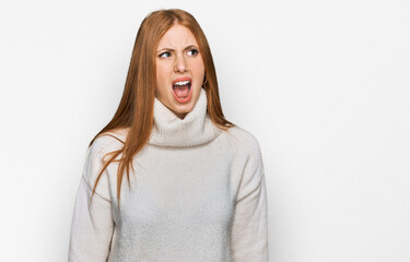 Young irish woman wearing casual winter sweater angry and mad screaming frustrated and furious, shouting with anger. rage and aggressive concept.