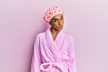 Hispanic man wearing make up wearing shower towel cap and bathrobe skeptic and nervous, frowning upset because of problem. negative person.