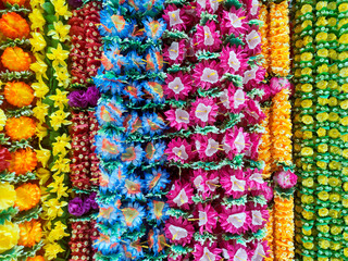 Many various colours flowers abstract pattern backgrounds, artificial flowers and garlands at shop at local market, Religious festivals and special events