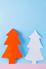 Naklejka na ściany i meble Paper Christmas trees on a blue-pink background. White and red paper christmas trees. Christmas minimal concept