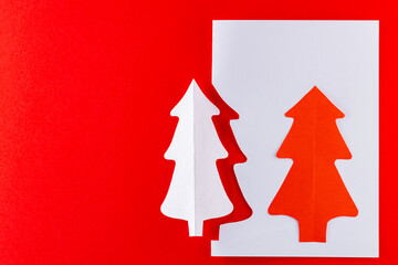 Fototapeta na wymiar Paper Christmas tree on a red background. White paper christmas tree. Christmas minimal concept