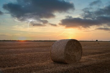 hay lies in a field at sunset