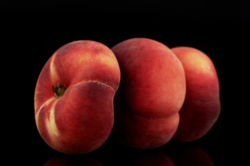 Three organic ripe fig peaches, close-up, isolated on black.