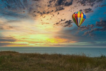 hot air balloon flies over the sea