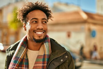 Young african american man smiling happy standing at the city