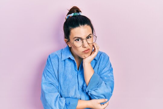 Young hispanic woman wearing casual clothes and glasses thinking looking tired and bored with depression problems with crossed arms.