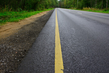 Obraz premium An asphalt road with markings outside the city going into the distance