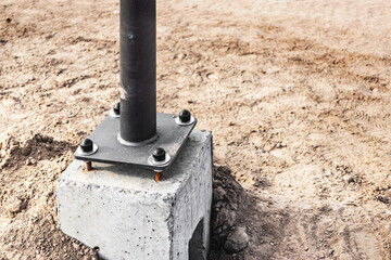 Installation of lighting poles on a concrete base. Electrification of the city. Construction work...