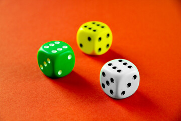 Three colorful dices isolated on orange background