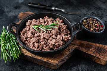 Fried mince beef meat in a pan for cooking pasta. Black background. Top view