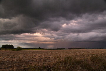 Lumière du soleil couchant sur les nuages d'orages au dessus des champs au bourg de Champagne au Périgord Vert