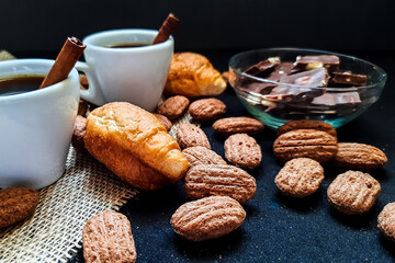Two small mugs of coffee with cinnamon and croissants