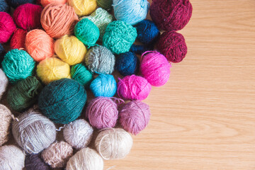 Ovillos de lana de diferentes colores y tamaños  sobre un fondo de madera. Crochet, ganchillo. Bolas de hilo. Madejas.
