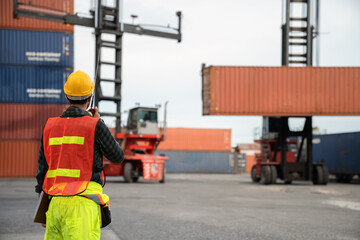 Engineer  use walkie-talkie in order to control container from Cargo freight for import and export.